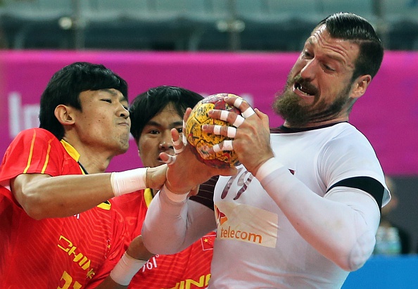 A battle for the ball in the handball, as China's Song Pengqiang (left) fought for it with Qatar's Borja Vidal in their preliminary round match ©AFP/Getty Images
