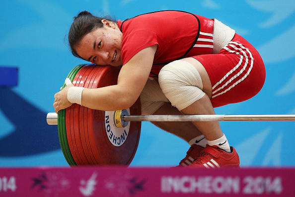 A hug for the weights is an unusual sight, but Zhazira Zhapparkul of Kazakhstan was thrilled with her efforts in the women's 75kg event ©Getty Images