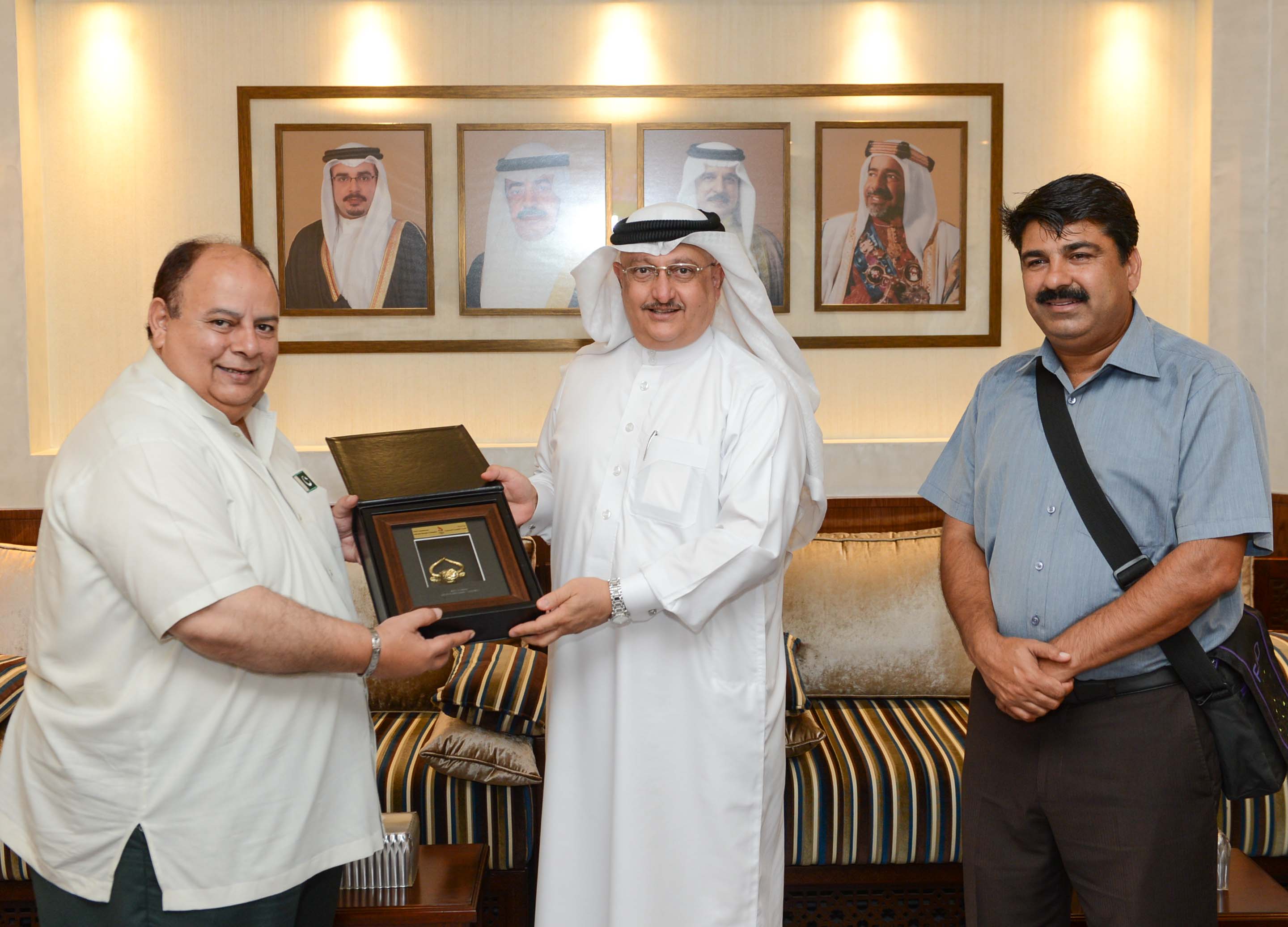 Abdulrahman Askar (centre) presented a memento to Asghar Khan during their meeting ©Bahrain Olympic Committee