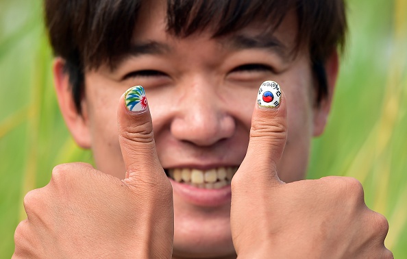Getting fully into the spirit of things, South Korean cycle coach Chung Jeong-Seok had his nails printed with the national flag and the Games logo ©AFP/Getty Images