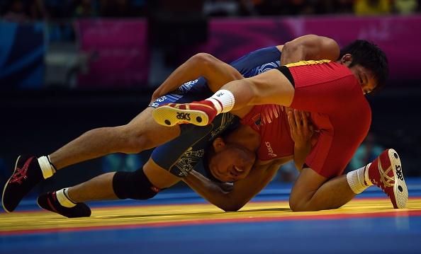 Fumitaka Morishita of Japan is flipped by Mongolias Nomin Batbold in the under 57kg wrestling ©AFP/Getty Images