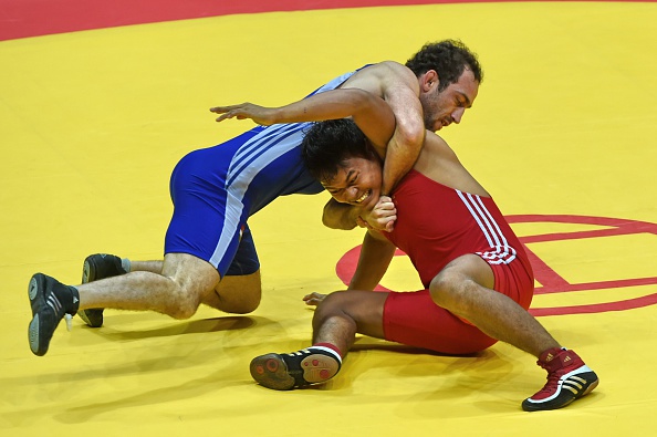 Myanmar's Tun Zaw Myint (red) was up against Tajikistan's Azamat Sufiev in the men's freestyle 74kg wrestling qualifications ©AFP/Getty Images