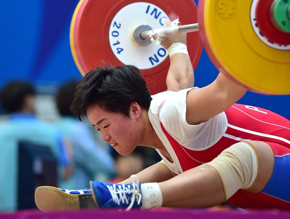North Korea's Jo Pok-Hyang fell as she missed a lift in the snatch of the women's 63kg weightlifting ©AFP/Getty Images