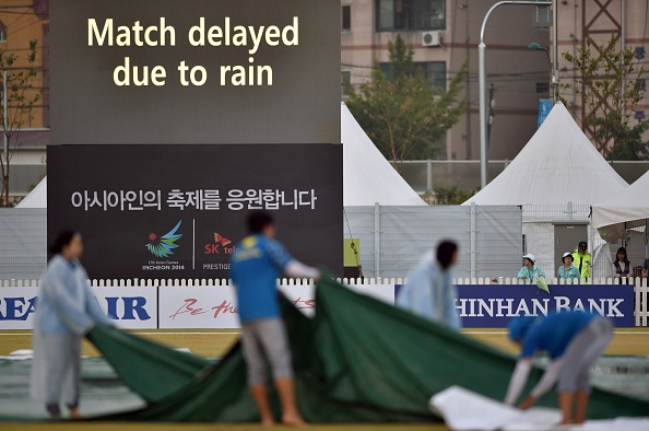 Officials covering the pitch at the cricket ©AFP/Getty Images