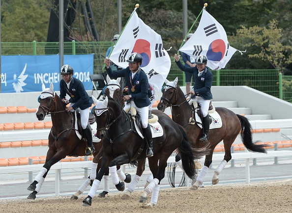 South Korea's gold medal winners in the equaestrian team jumping event proudly waved their nation's flag to celebrate ©AFP/Getty Images