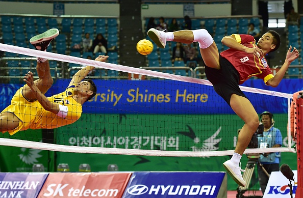 Thailand's Suriyan Peachan (left) challenged for the ball with Malaysia's Mohamad Fadzli Bin Muhammad Roslan in the men's team sepak takraw ©AFP/Getty Images