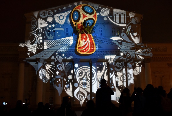 People watch as the facade of the historical Bolshoi Theatre is illuminated with the official emblem of the 2018 FIFA World Cup ©Getty Images