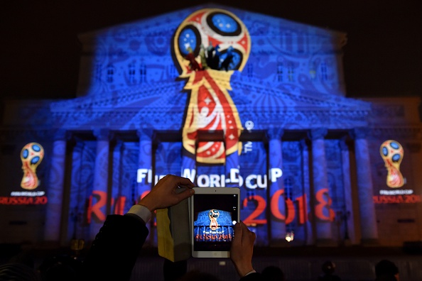 A spectator takes a picture as the facade of the historical Bolshoi Theatre is illuminated with the official emblem of the 2018 FIFA World Cup ©Getty Images