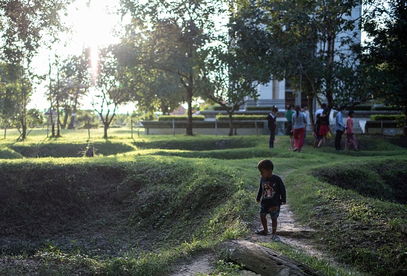A recent image shows a child looking at the site of mass graves for victims of the Khmer Rouge at the infamous Choeung Ek killing fields ©Getty Images