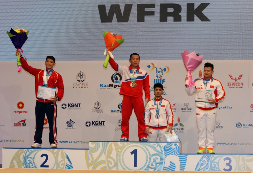 North Korea's Om Yun Chol celebrates his gold medal at the IWF World Weightlifting Championships in Almaty alongside silver medallist, Vietnam's Kim Tuan Thach, and bronze medallist, China's Long Qingquan