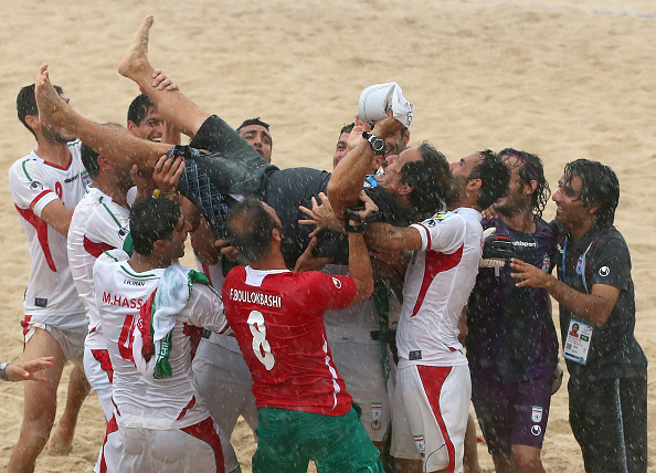 The Iran coach is raised into the air after his side wins the men's beach soccer title ©Getty Images