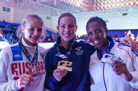 Elin Johansson (centre) celebrates her gold medal with silver medallist Haby Niare (right) and bronze medallist Anastasiia Baryshnikova (left) ©WTF