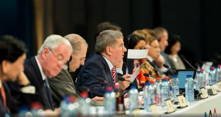 Thomas Bach waves a copy of the Olympic Agenda 2020 recommendations ©IOC