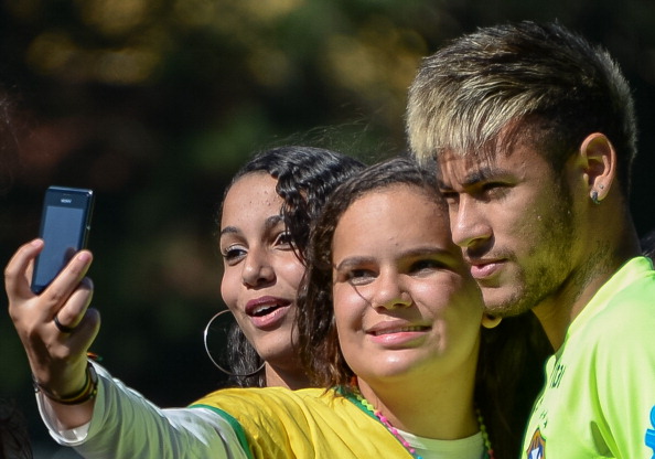 The ultimate memento for football fans - a selfie with a star. Two young women grab the goods here with Neymar during Brazil training in this year's World Cup finals ©Getty Images