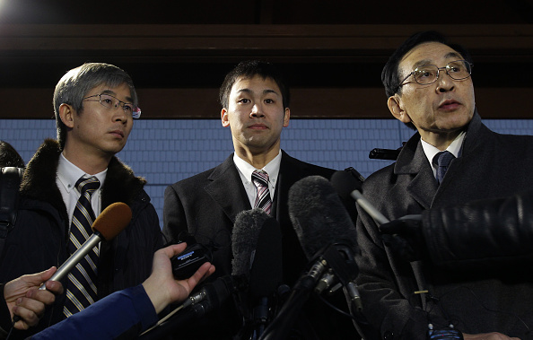 Japanese swimmer Naoya Tomita (centre) speaks to the media after appearing in court, accused of stealing a camera during the Asian Games ©Getty Images