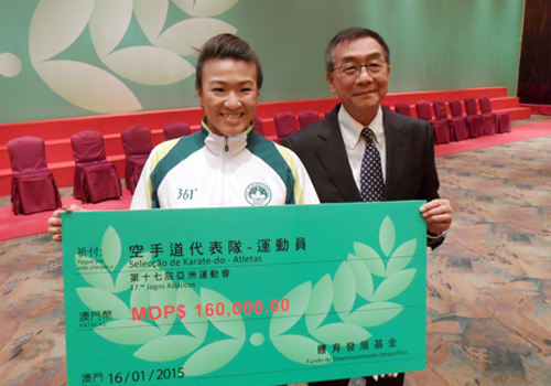 Paula Carion, who won a bronze medal in karate at the 2014 Asian Games, accepts the reward for her achievement from Sports and Olympic Committee of Macau President Charles Lo Keng Chio ©OCA