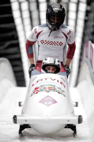 Oskars Melbārdis, pictured settling into his two-man bob ahead of brakeman Daumants Dreiškens at the Sochi 2014 Games, has won overall World Cup titles this year in both the two and the four-man bob ©Getty Images