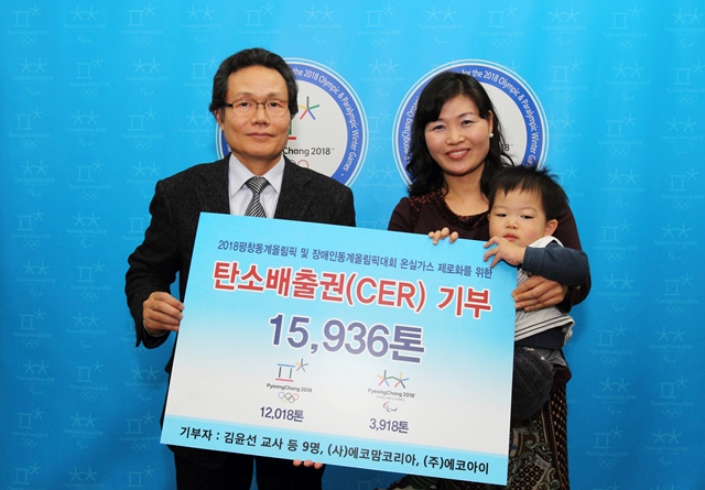 Sangpyo Kim (left), POCOG vice-president of venues and infrastructure, accepts the CERs contribution certificate from Youn-sun Kim (right), a teacher at Yeonhui Elementary School ©POCOG