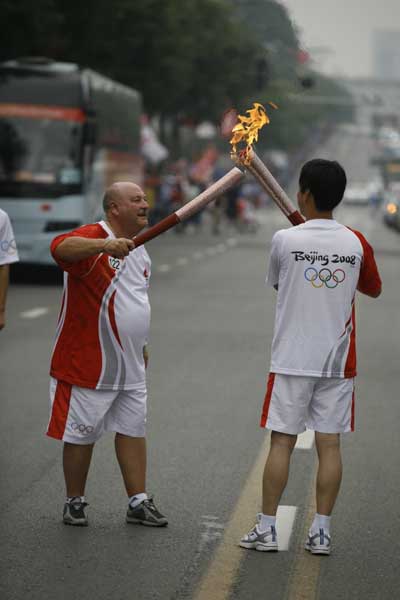 Alan_Hubbard_hands_over_the_flame_to_Huang_Yan_Hua_chairman_of_the_Xian_shooting_association_01-08-11
