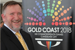 Mike_Hooper_in_front_of_Gold_Coast_logo