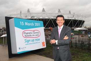 Sebastian_Coe_outside_Olympic_Stadium_with_sign_up_notice