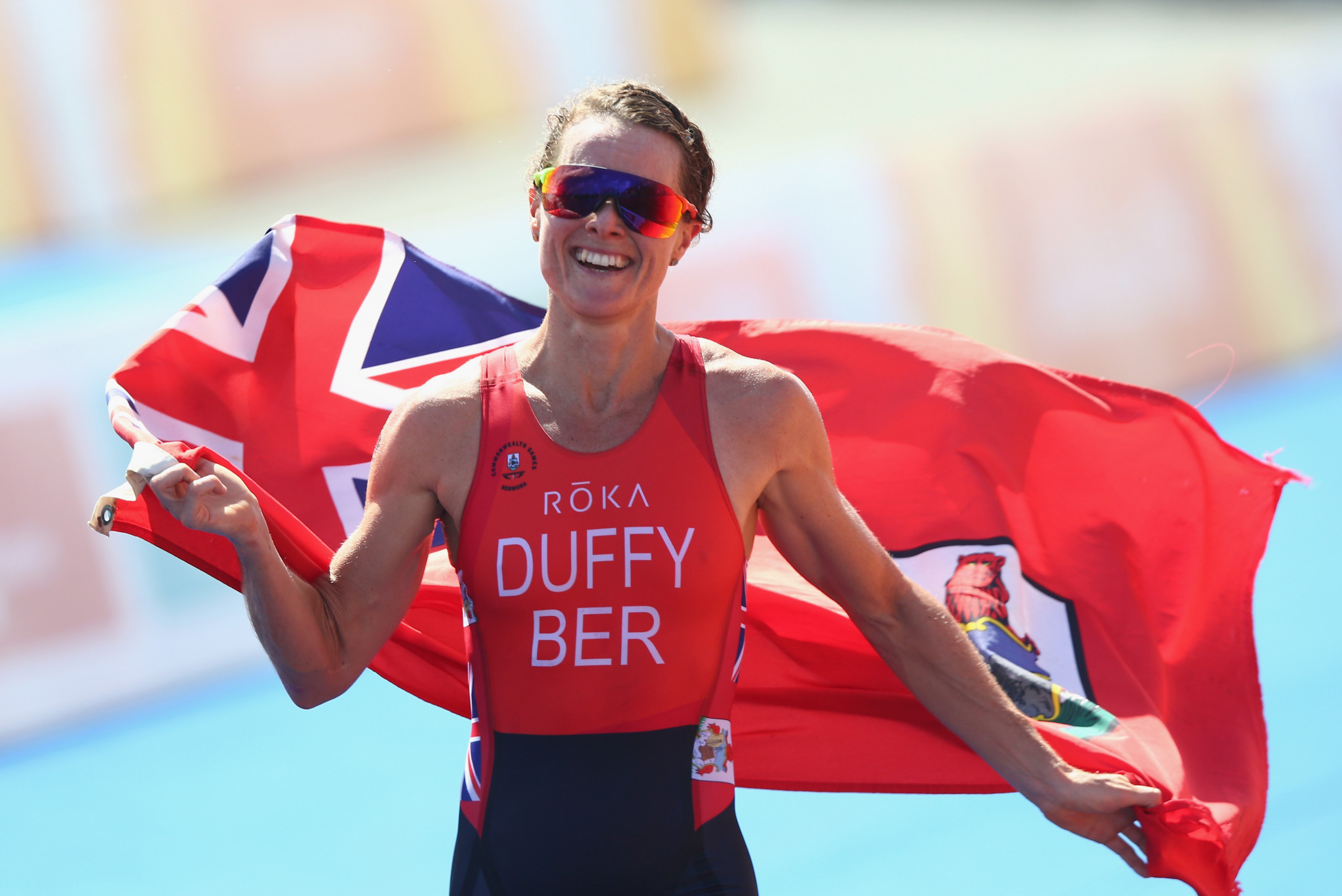 Flora Duffy of Bermuda celebrates on her way to winning gold during the Women's Triathlon on day one of the Gold Coast 2018 Commonwealth Games ©Getty Images